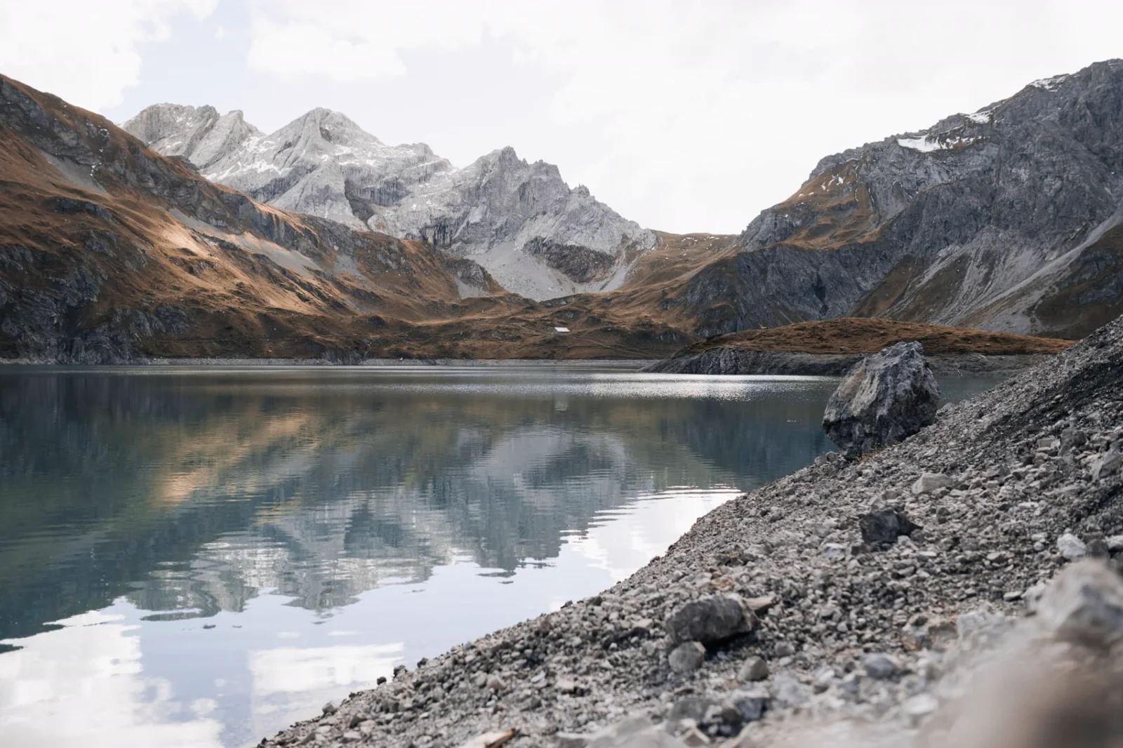 Weiter Bergsee in ruhigem Licht
